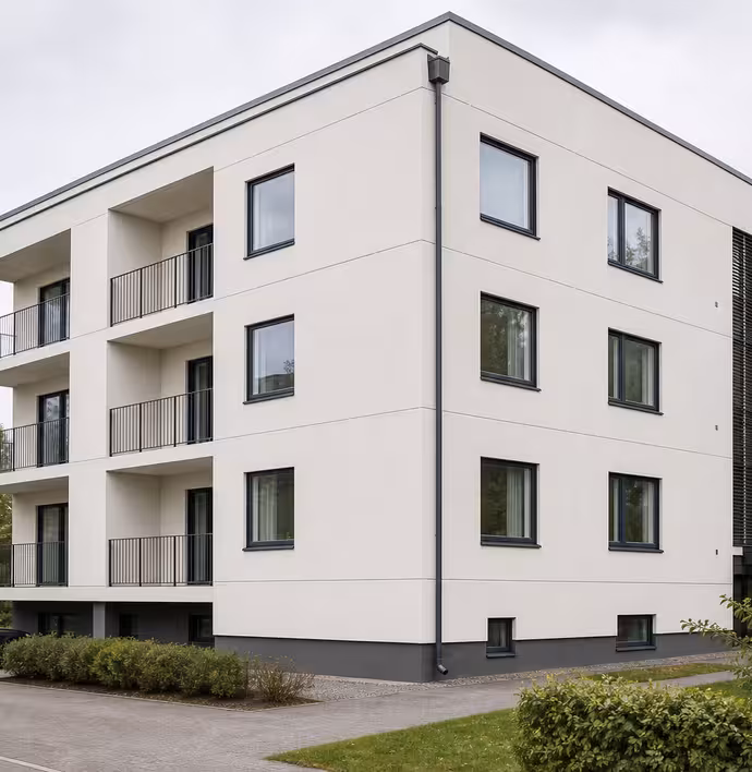 Vaalea taloyhtiön julkisivu juuri maalauksen jälkeen.